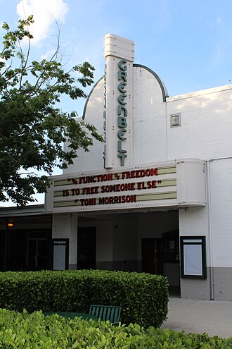 The Greenbelt Cinema, with its semi-circular 
awning and its movie marquee showing red letters on a white background