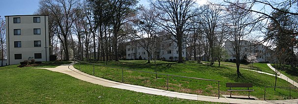 middle-rise apartments near Parkway, with 
grass and curved walking paths in the foreground